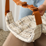 A Chekoh Clip Carrier waistband is held up by two hands, demonstrating how the Size Extender Strap Clips into the existing waistband clip to extend the measurement for plus size/inclusive wear.