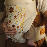 Person holding a baby in a floral-embroidered print Chekoh baby carrier. Juni close up details of the Clip Carrier 2.0