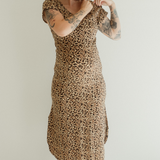 A pregnant mother demonstrates the pull down front feature of the Leopard print Journey Dress by Chekoh.
