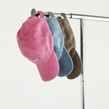 Pink, Lightwash Denim, Bone Chekoh Baby Caps lined up on a metal clothing rack with white backdrop. The full range of Mum Caps.