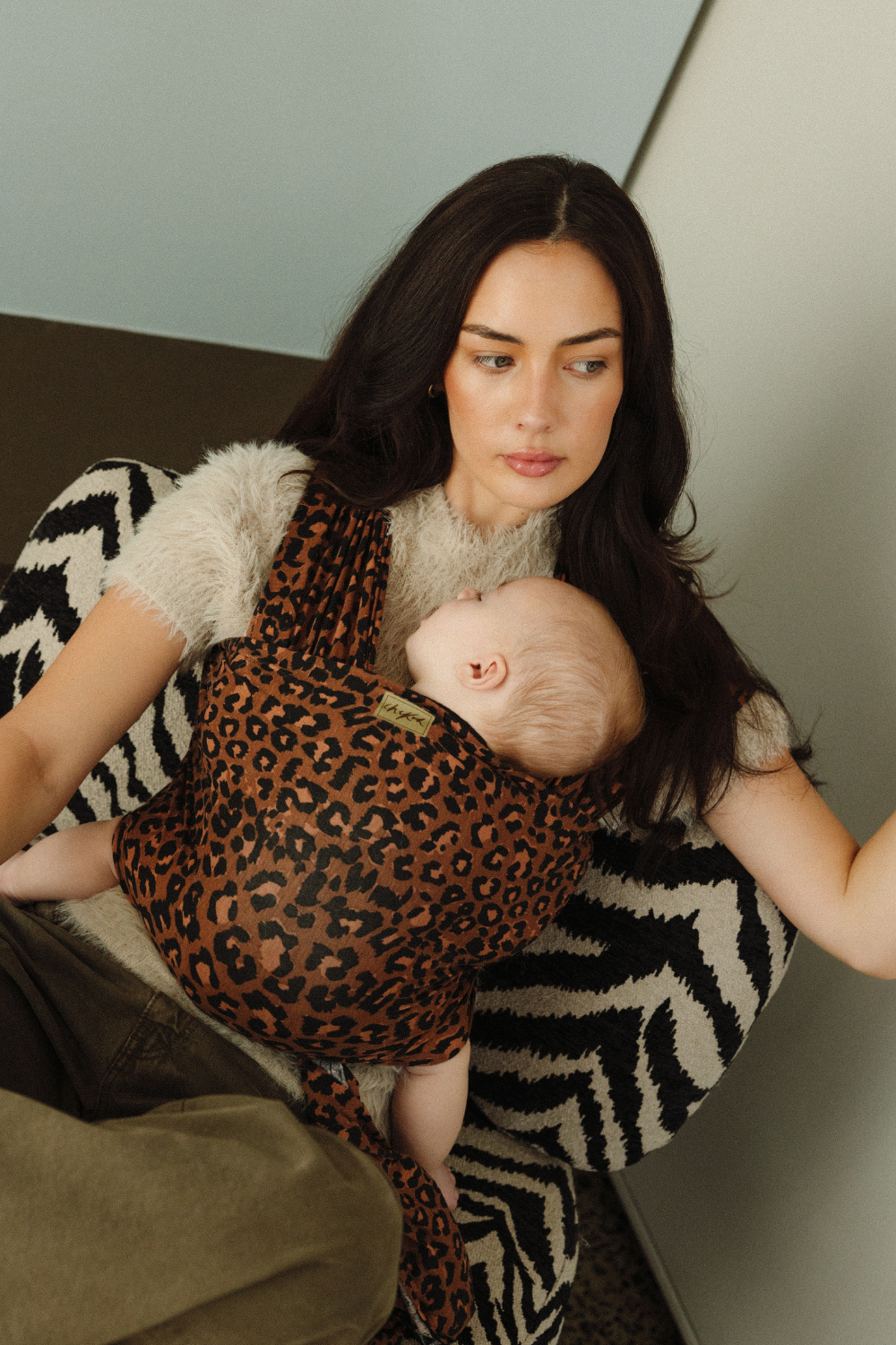 Mother, Reina, is keeping her little baby close with the help of a Chekoh Baby Wrap in the Leopard print. 