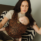 Mother, Reina, is keeping her little baby close with the help of a Chekoh Baby Wrap in the Leopard print. 