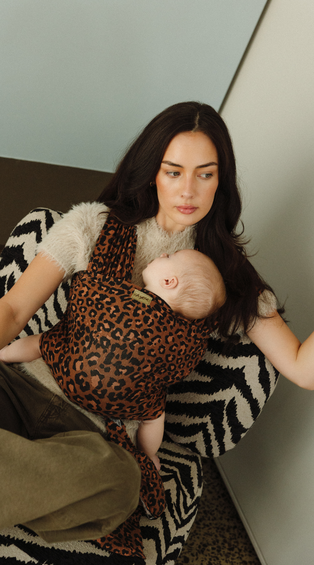 Mother, Reina, is keeping her little baby close with the help of a Chekoh Baby Wrap in the Leopard print. 