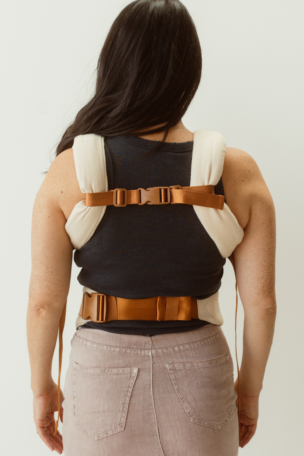 Example of how to wear the Chekoh Chest Strap - image shows woman wearing the Clip carrier with the Chest Strap affixed at her back to create a 'H' style carry.