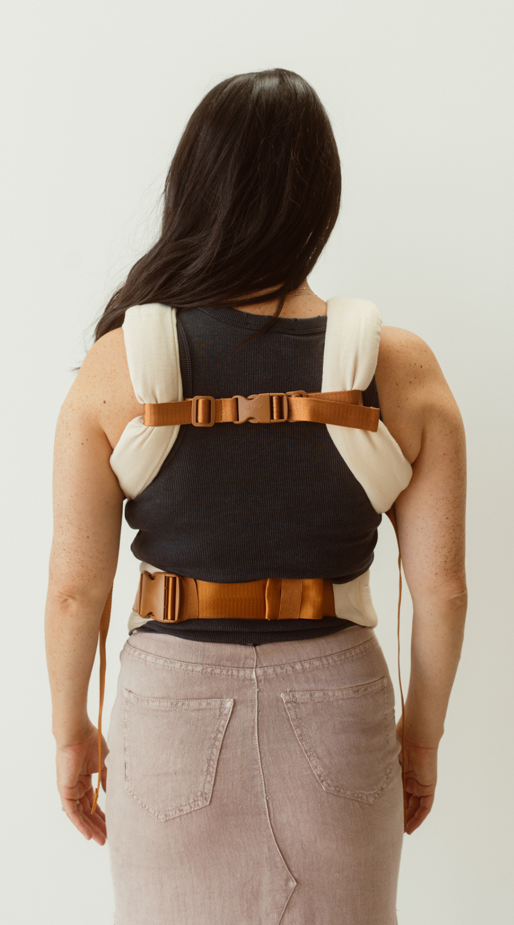 Example of how to wear the Chekoh Chest Strap - image shows woman wearing the Clip carrier with the Chest Strap affixed at her back to create a 'H' style carry.
