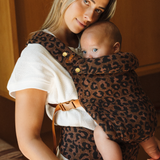 Mom and baby are enjoying a close moment in the Chekoh Baby Carrier in Leopard. Baby is close enough to kiss and resting gently against moms chest.