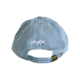 Back of Denim Chekoh Cap with Chekoh logo embroidered in white on a light wash blue denim Cap