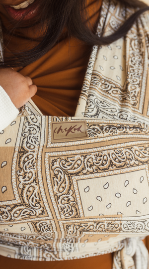 Chekoh Baby Carriers Newborn Wrap Carrier in Bandana print. Neutral colours in beige, cream and ochre for the most perfect style. 