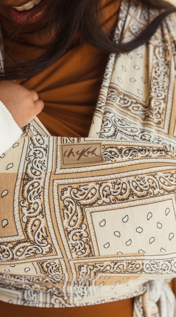 Chekoh Baby Carriers Newborn Wrap Carrier in Bandana print. Neutral colours in beige, cream and ochre for the most perfect style. 