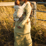 Mother in a field in Australia, wearing the limited edition folk art embroidered Juni Clip Carrier. A cotton velvet base crafted in small batches.