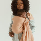 A mom wears the Chekoh Ring Sling in the shade Terracotta 