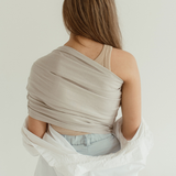 A mom faces away while wearing the Chekoh Baby Ring Sling in Asha grey.
