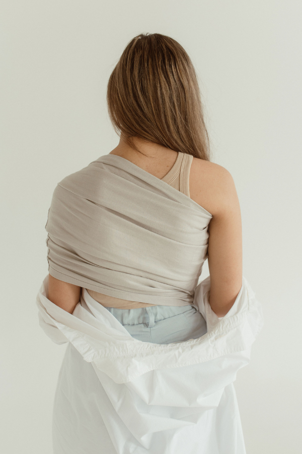 A mom faces away while wearing the Chekoh Baby Ring Sling in Asha grey.