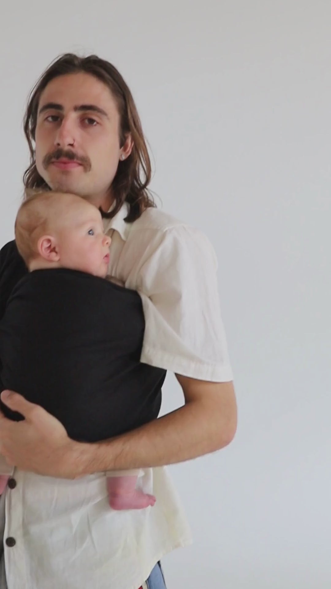 A video of a gather, sharing close moments with his little baby, carried close in the Baby Sling Carrier by Chekoh in the colourway Jett (a classic and best-selling black) 