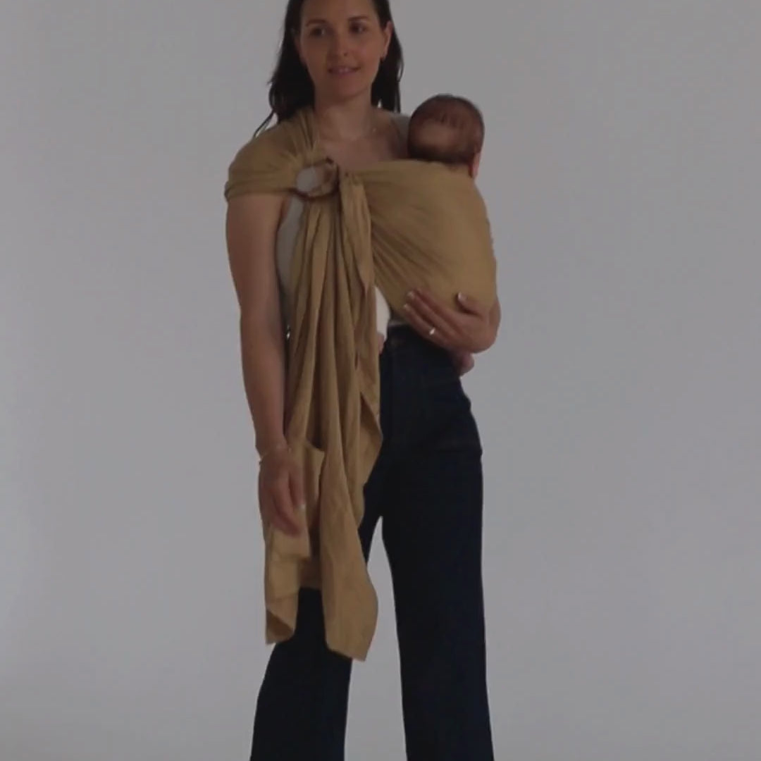 A video of a mother and baby wearing the Ring Sling Baby Carrier, designed in Australia, by Chekoh Baby - they are walking across a plain white backdrop. 