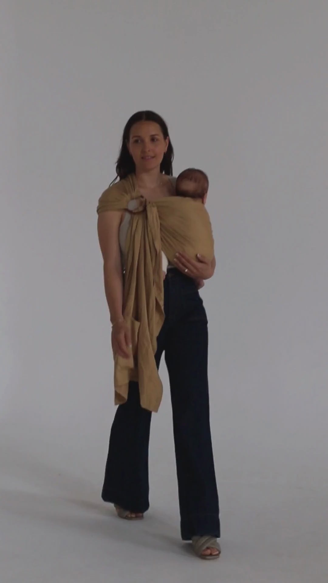 A video of a mother and baby wearing the Ring Sling Baby Carrier, designed in Australia, by Chekoh Baby - they are walking across a plain white backdrop. 